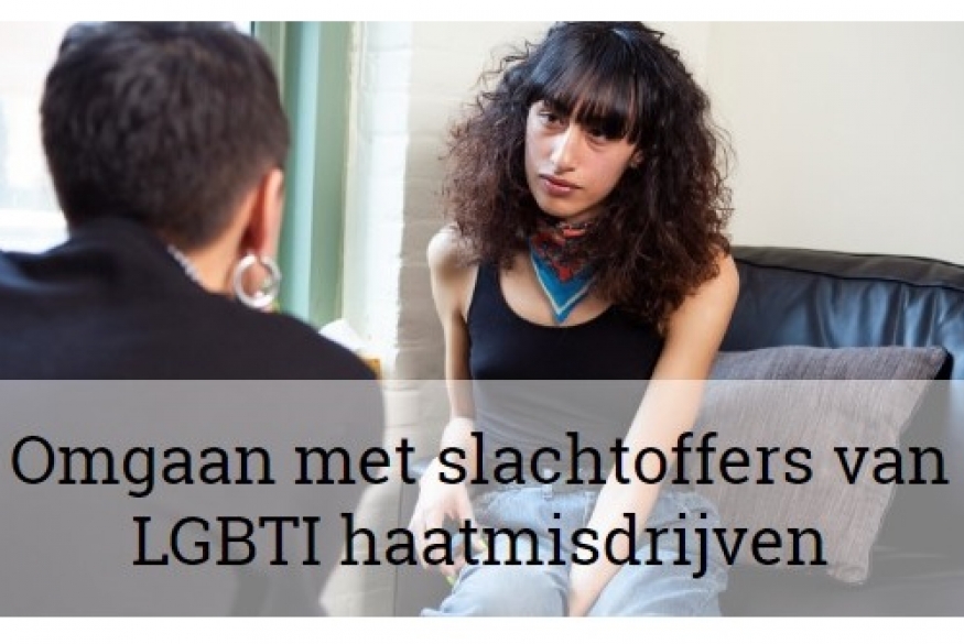 persoon met lang donkere krullend haar zit neer in een zwart leren zetel, tegenover hen zit iemand met kort haar en grote zilverkleurige oorringen