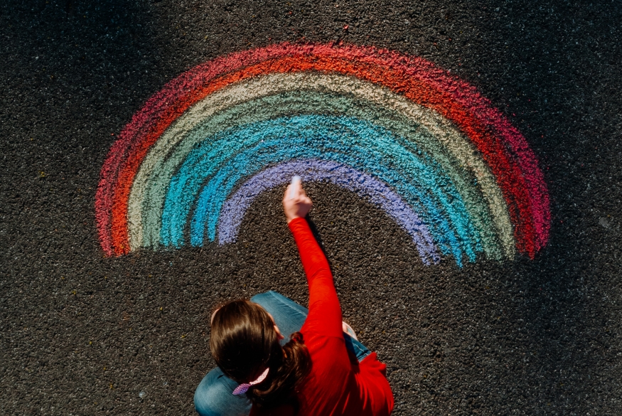 Regenboog Persoon tekent regenboog op de straat met krijt