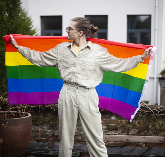 Persoon die regenboogvlag achter zich vasthoudt