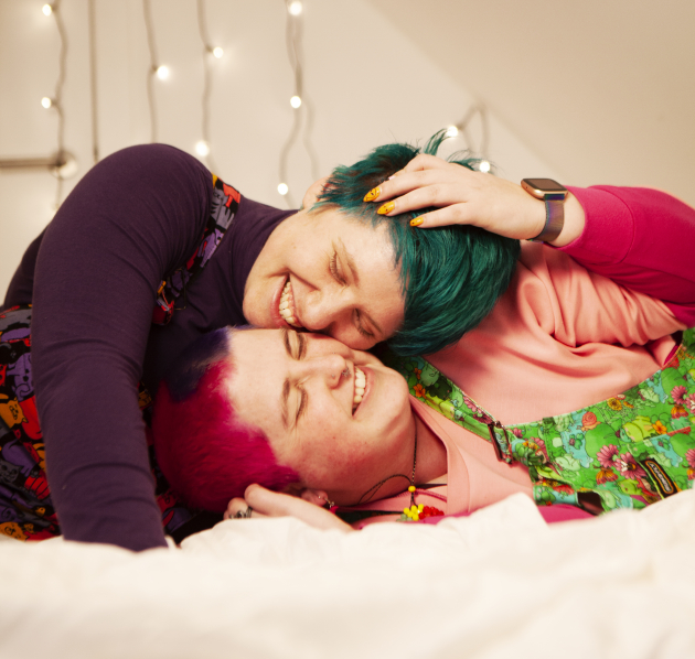Twee personen die samen in bed liggen knuffelen