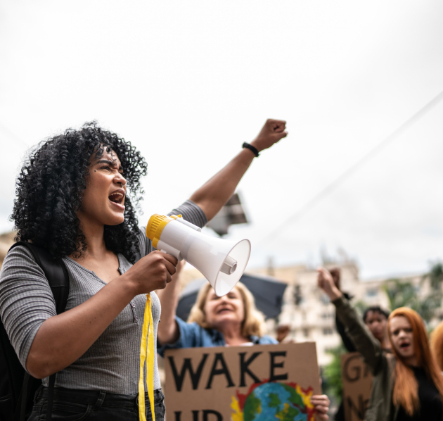 Persoon die megafoon vasthoudt en vuist in de lucht steekt 