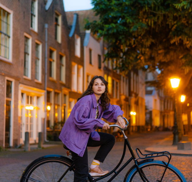 Leerling op de fiets in de stad in de schemering