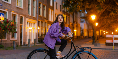 Leerling op de fiets in de stad in de schemering