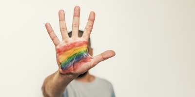 çavaria eist een kordate aanpak van haat, extremisme en geweld Iemand maakt het stopteken met hun hand. Op het hand staat een regenboogvlag gekleurd.