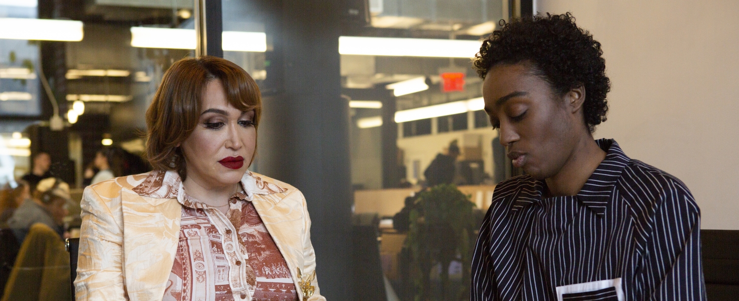 A transfeminine executive meeting with a non-binary employee