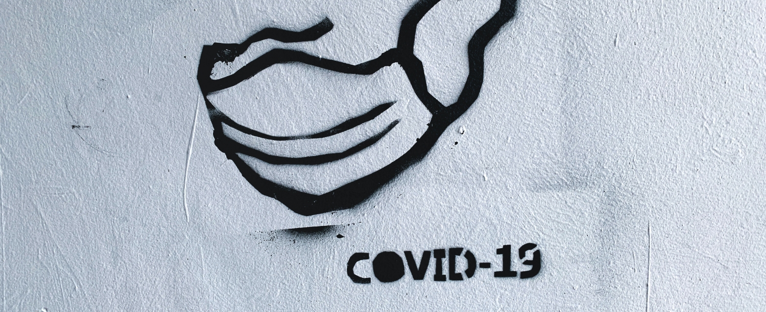 graffiti van een mondmasker met daarbij de tekst COVID-19