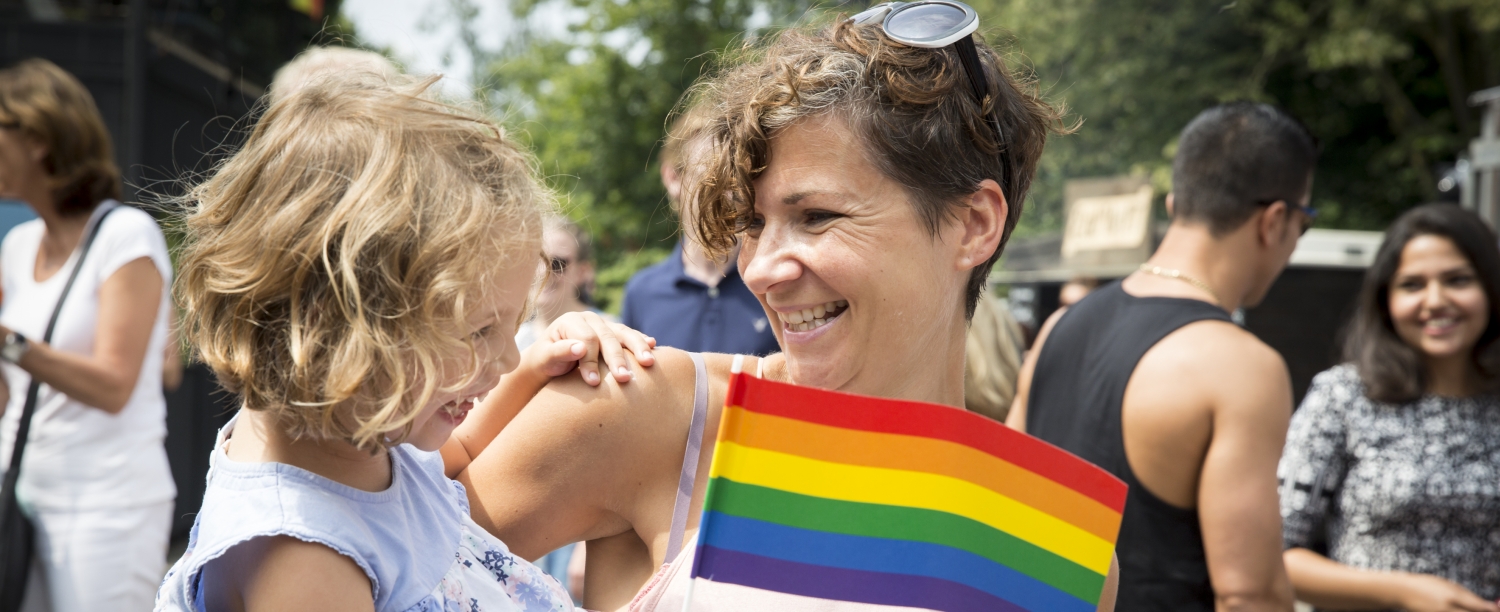 Volwassene met kind en regenboogvlag